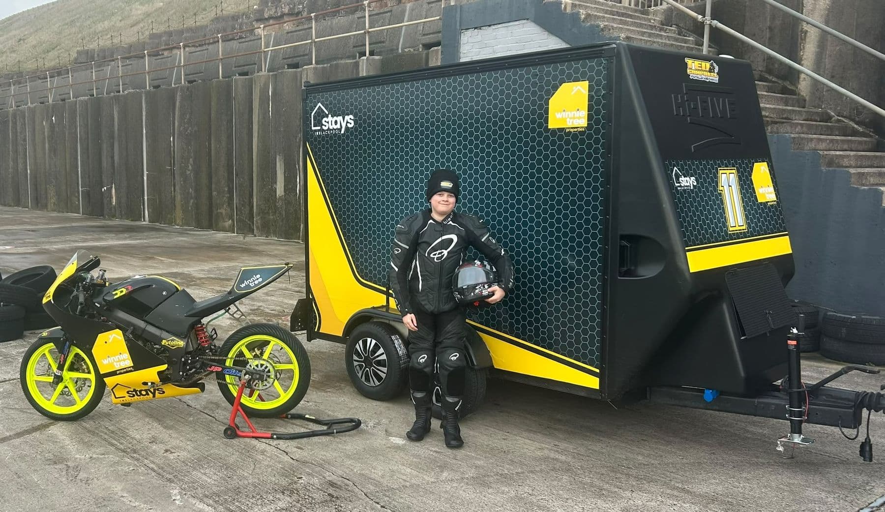 Ted in his leathers beside the bike and team trailer